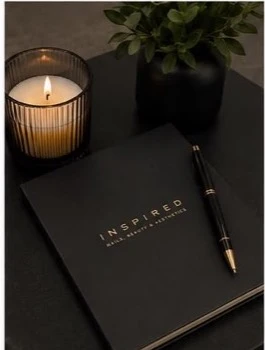 Inspired training notebook beside a candle and plant